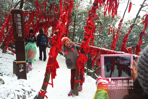 鬼谷棧道上掛滿祈愿帶的“紅樹林”在白雪中分外妖嬈，吸引游人拍照 丁云娟攝_副本.jpg